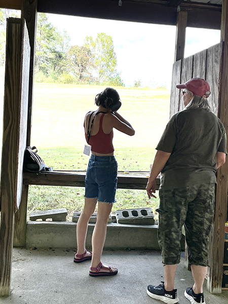 An instructor showing a person shooting down a rifle range