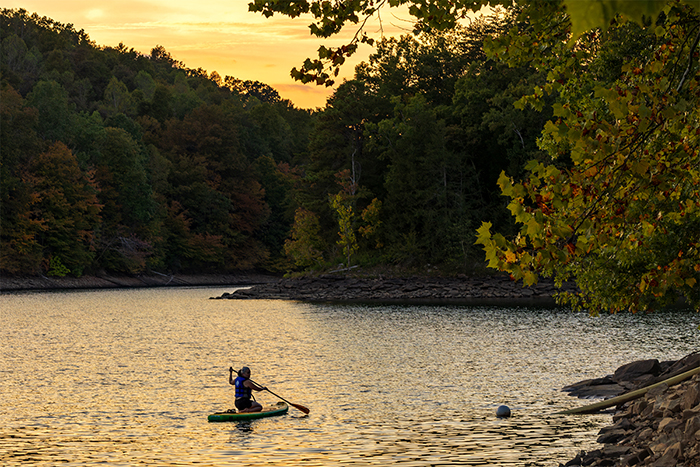 Sunset image showing a kayaker floating on a waterway