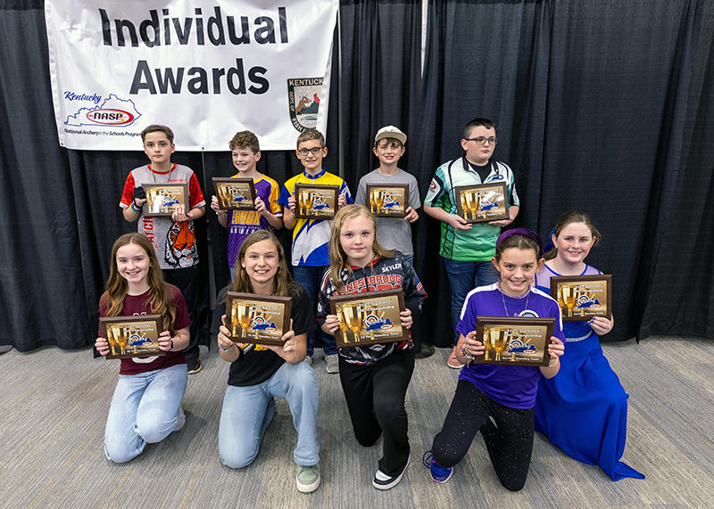 ten Students holding up placards in front of a sign that reads individual awards