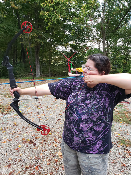 A woman shooting an genisis bow