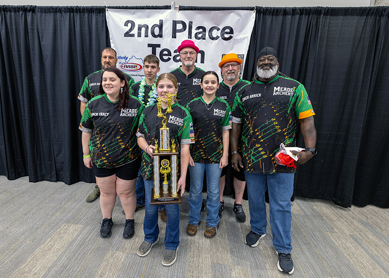 A group of four students and four adults in front of a sign that reads 2nd place team