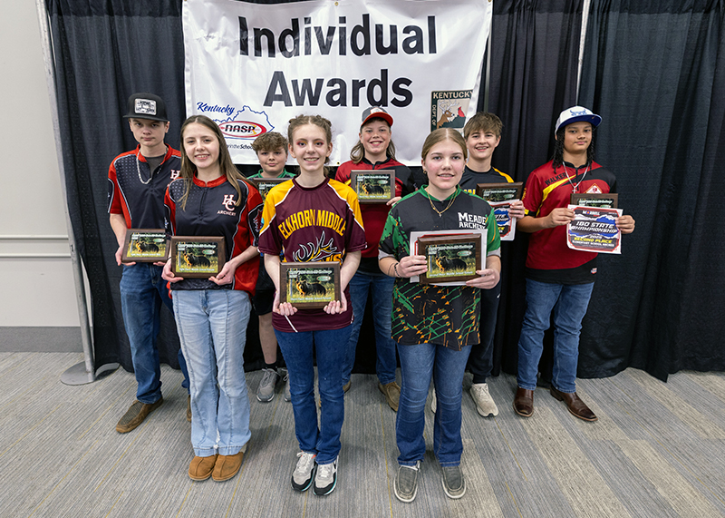 A group of eight students holding up a placards in front of a sign that reads individual awards