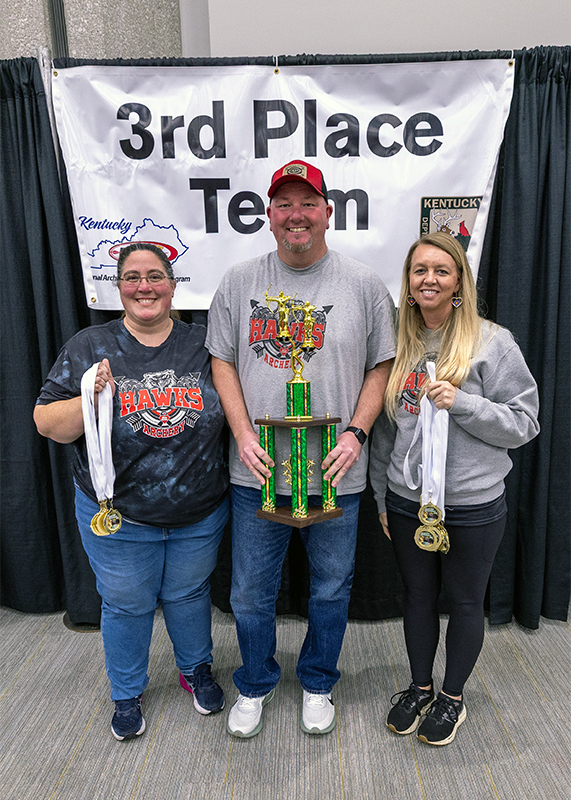 A group of seven students and two adults in front of a sign that reads 3rd place team