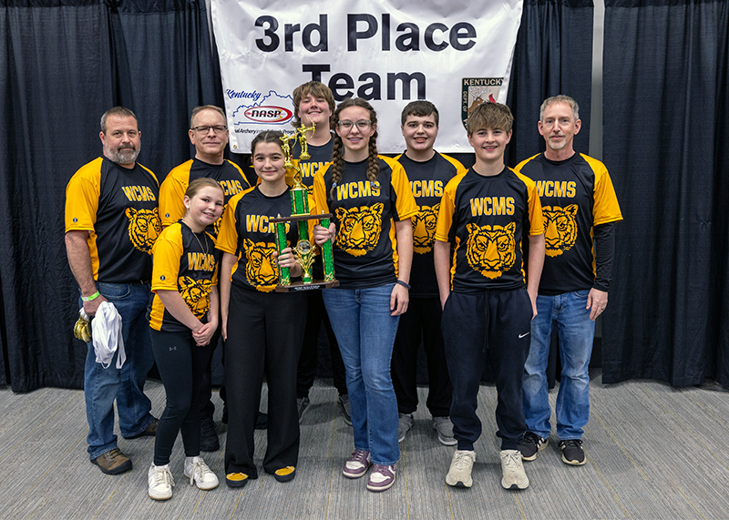 A group of six students and three adults in front of a sign that reads 3rd place team