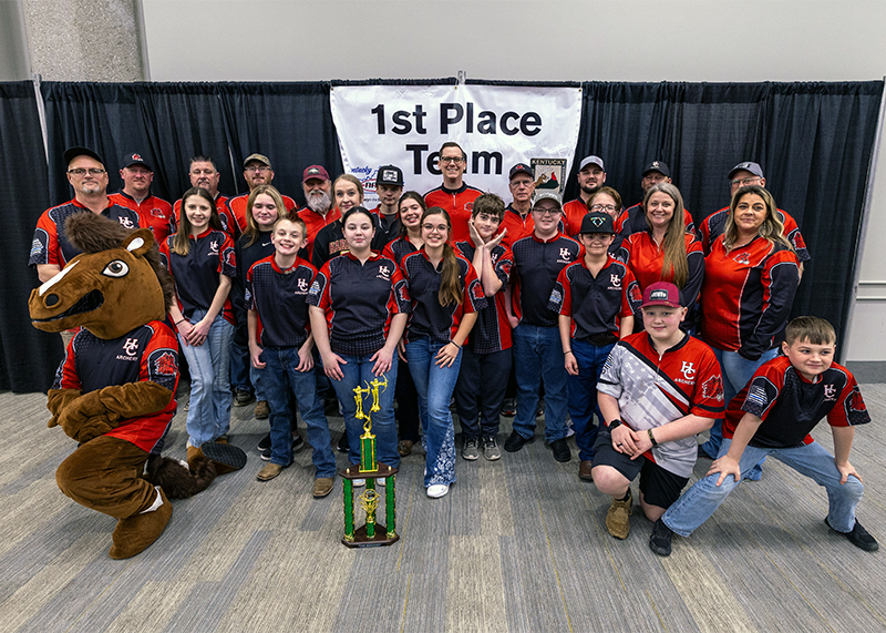 A massive group of students and two adults in front of a sign that reads 1st place team