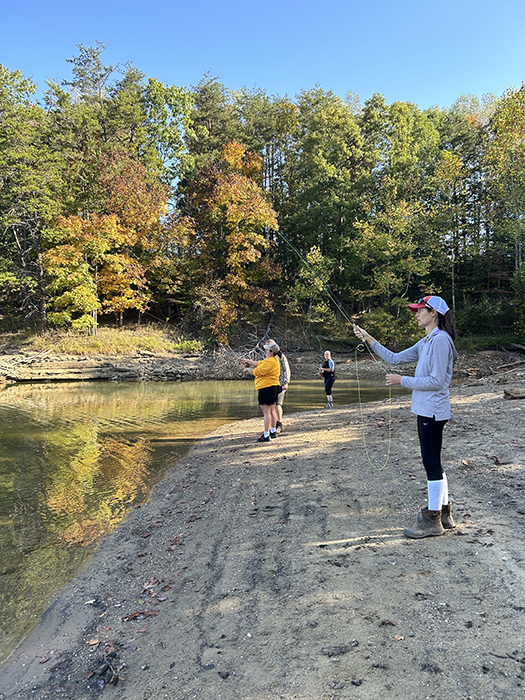 Women casting on the edge of a shoreline