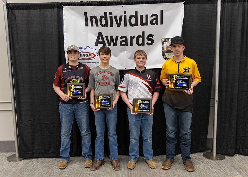 a group of students holding up plaques with a sign behind them reading individual awards