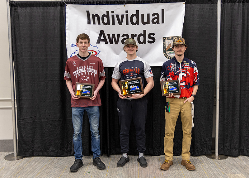 a group of students holding up plaques with a sign behind them reading individual awards