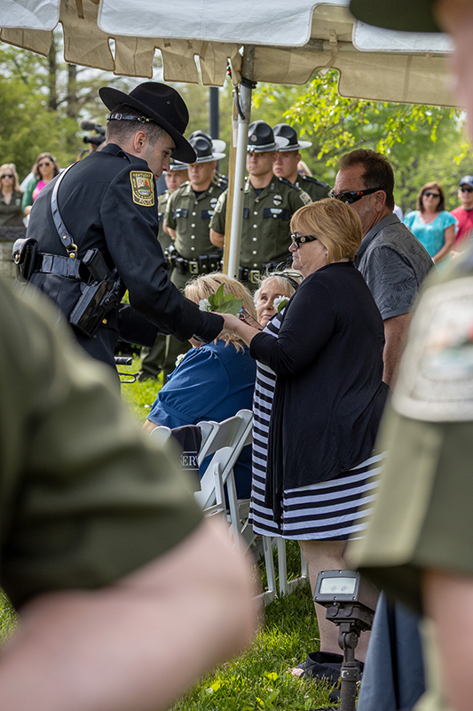 A bagpiper is playing between two officers