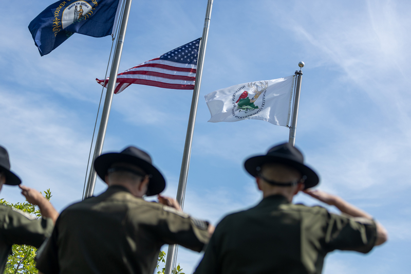 Conservation Officers stand and salute the Commonwealth flag, the American Flag and the Fish and Wildlife Flag