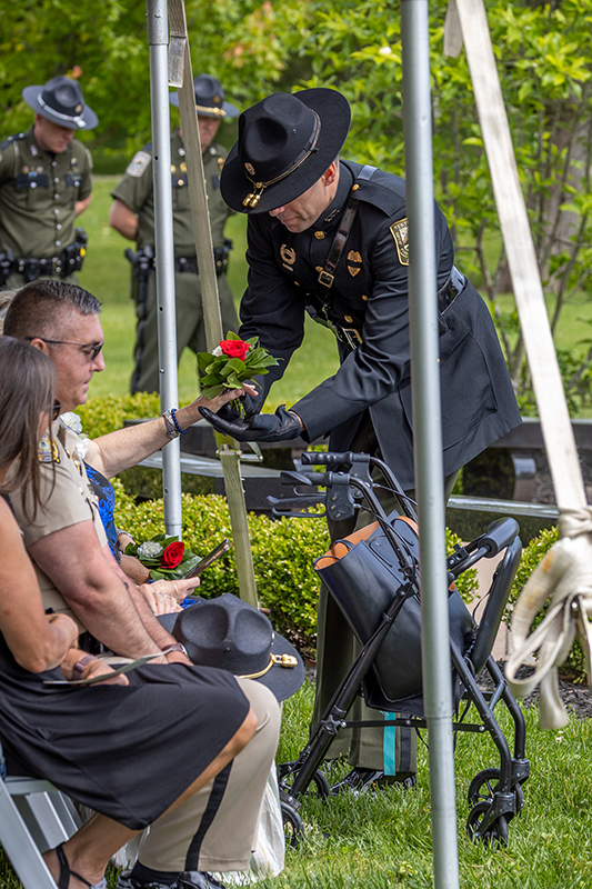An officer is standing at attention to a wreath in the center of the memorial