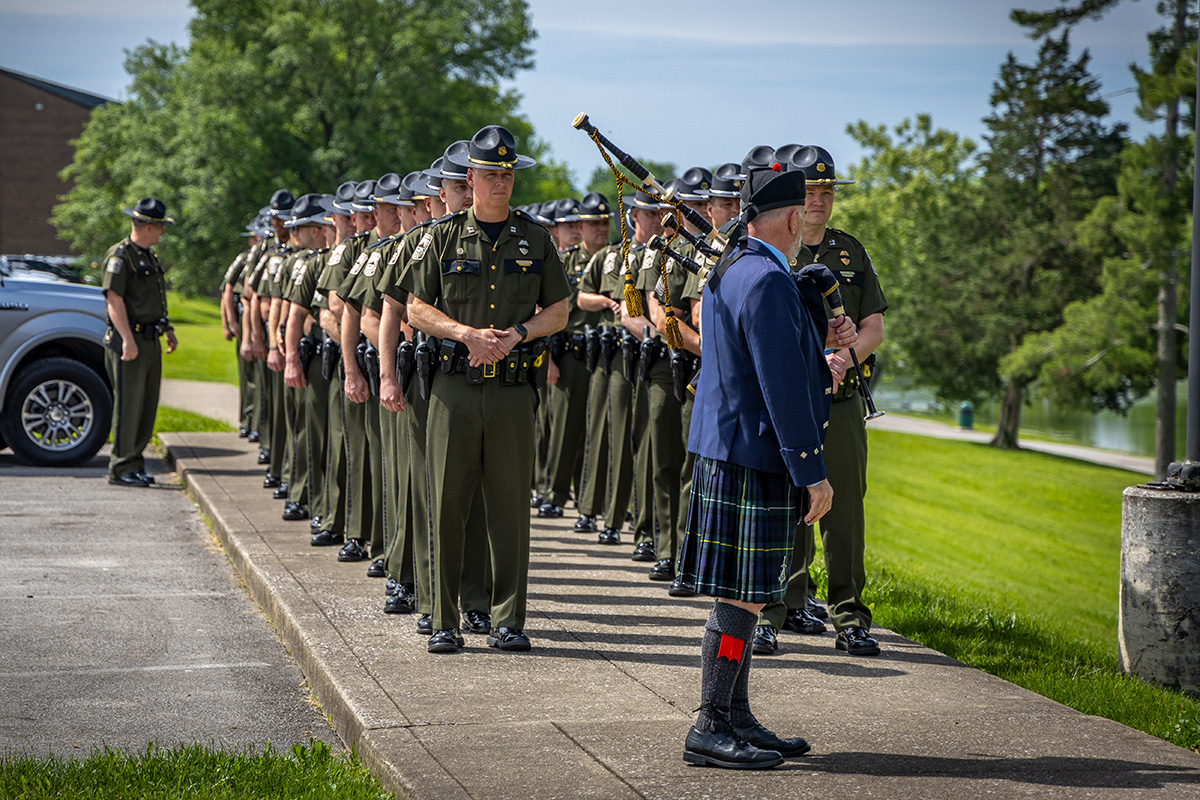 Four conservation officers and walking in a line in the center of the memorial