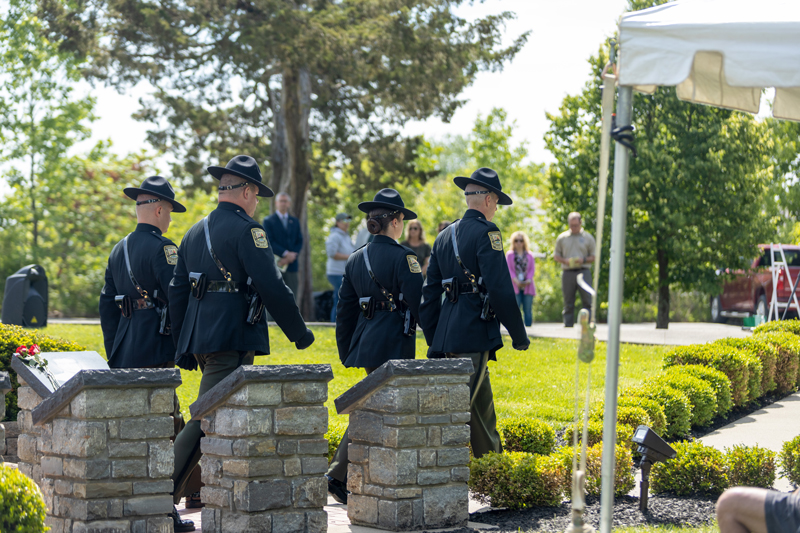 Four conservation officers walk in unison away from the Memorial