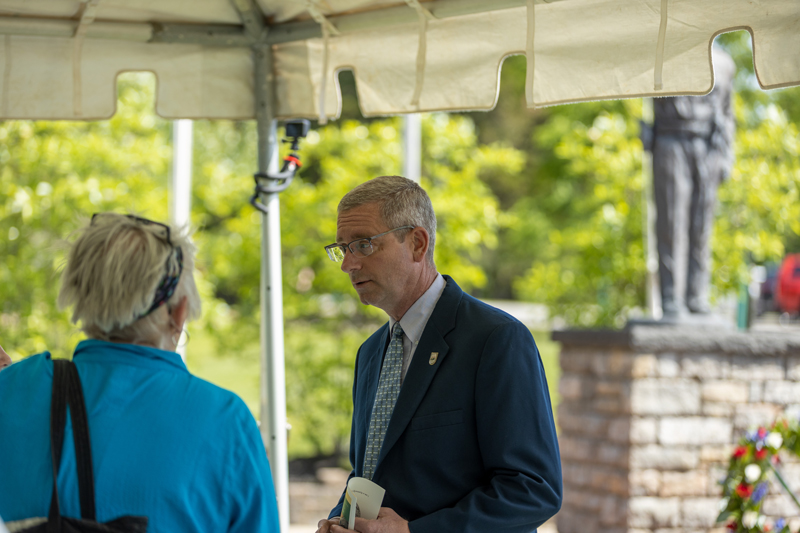 Depty Commissioner Clark speaks with a person under a tent