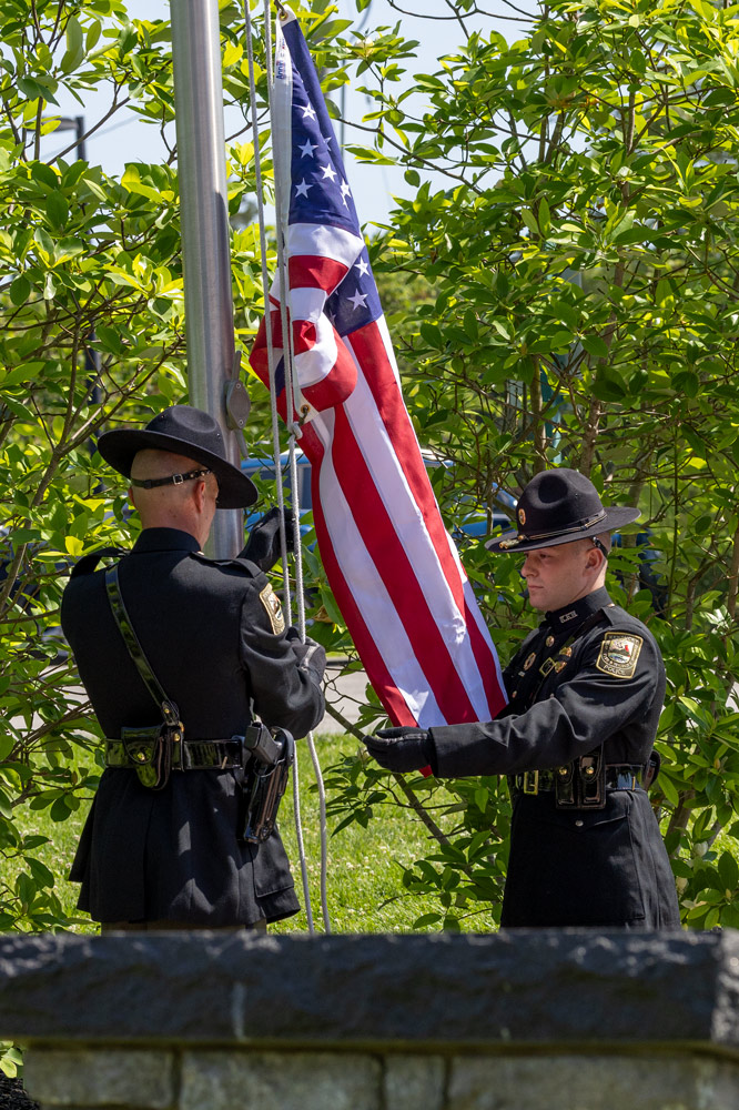 Two officers are installing an American Flag on a flag pole