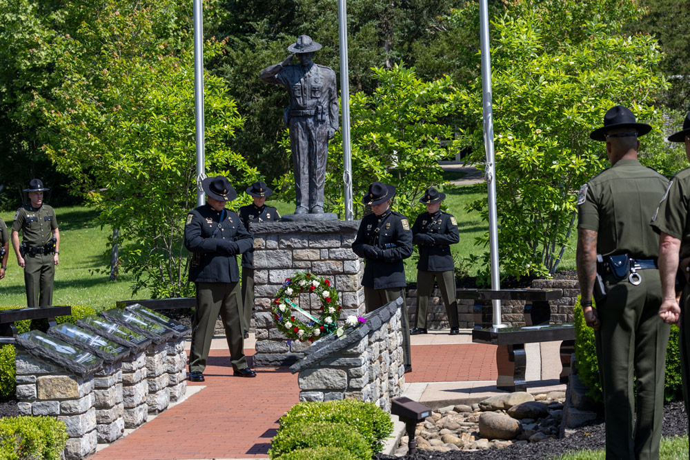 Four officers are standing in prayer in the center of the memorial