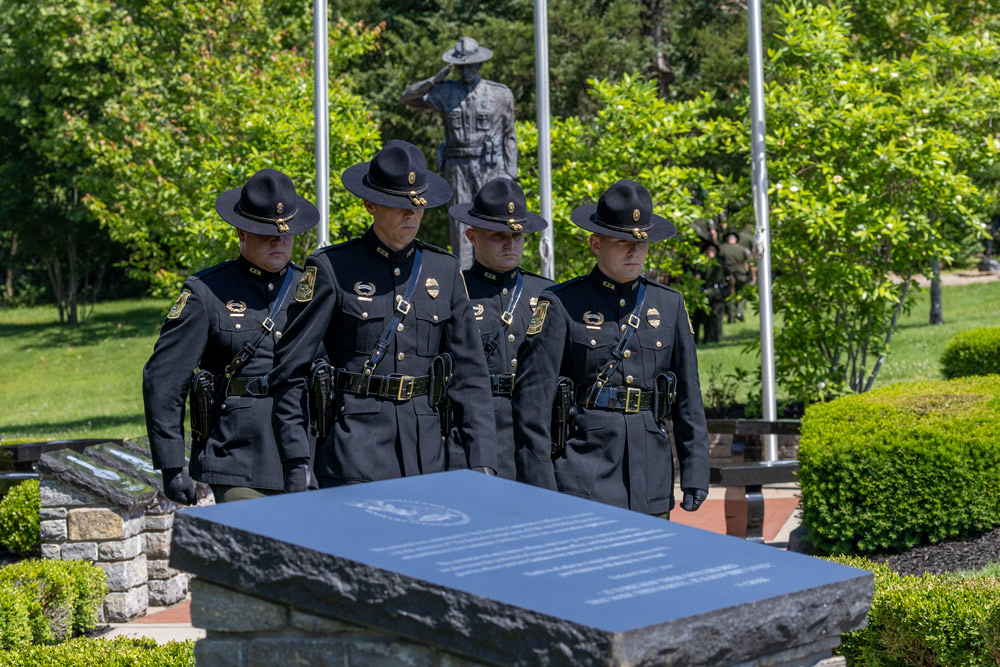 Four conservation officers and walking in a line in the center of the memorial