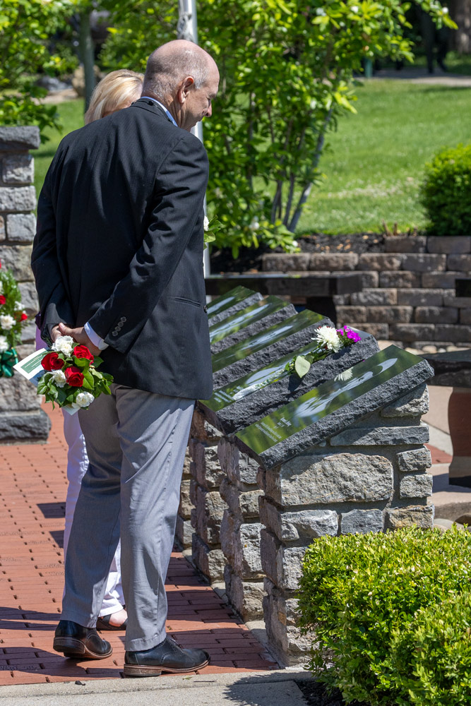 A man and woman are looking at memorial markers