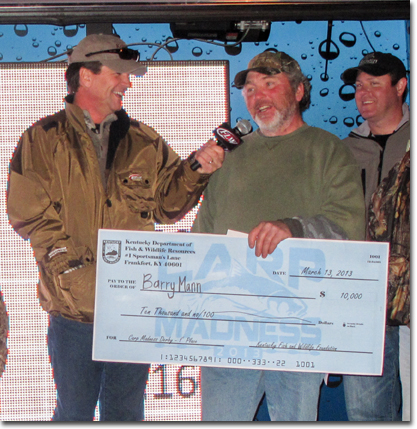 Tim Farmer and Chad Miles present a tired but jubilant Barry Mann a first prize check.