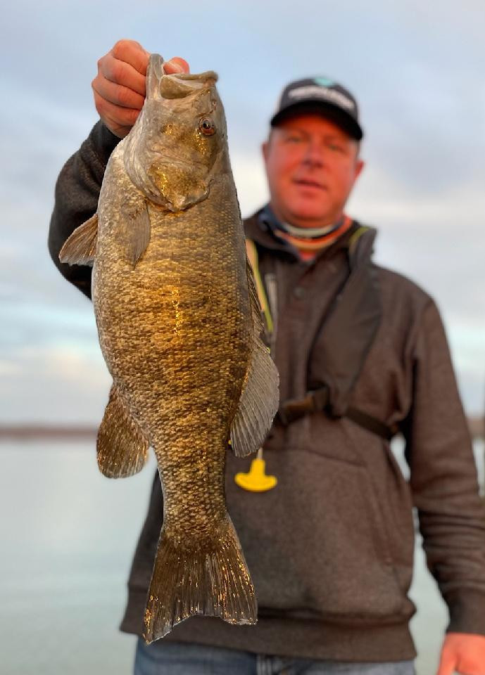 Chad Miles is holding up a trophy smallmouth bass