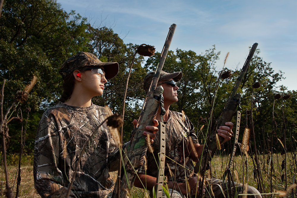  A young hunter seated in a dove field with a mentor