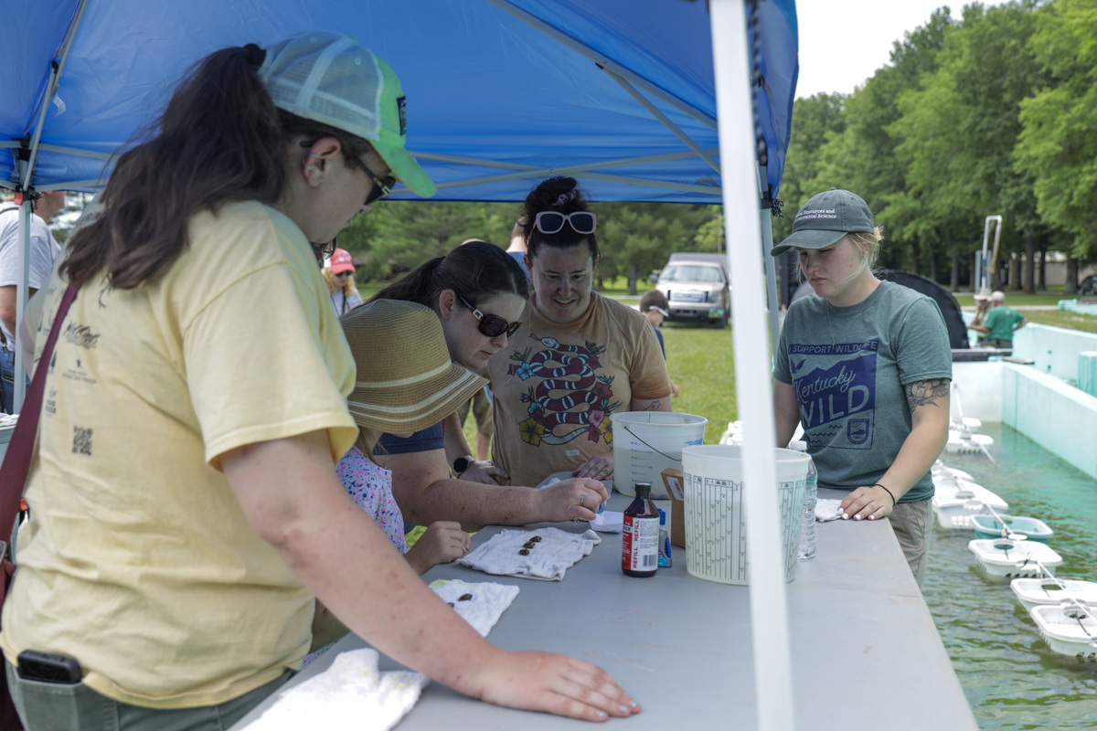 Fisheries biologist Julieann Jacobs teaches attendees how to glitter-tag native freshwater mussels raised at Minor Clark Fish Hatchery, photographer Ashley Reeves