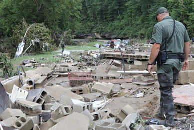 a man in an officers uniform is walking around foundation debris of a ruined house