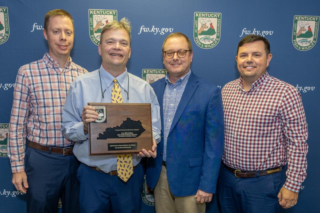 Pictured left to right Information and Education Division Assistant Director Nathan Brooks, Lee McClellan, Information and Education Division Director Kevin Kelly, and Commissioner Rich Storm.