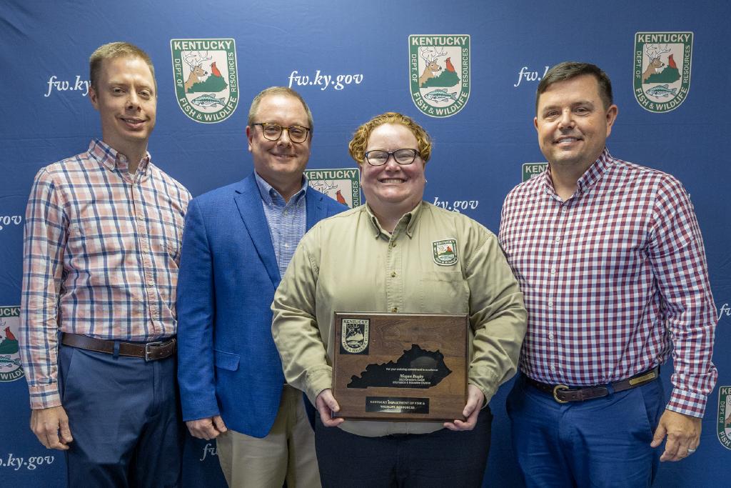 Pictured left to right Information and Education Division Assistant Director Nathan Brooks, Information and Education Division Director Kevin Kelly, Megan Bagby, and Commissioner Rich Storm.