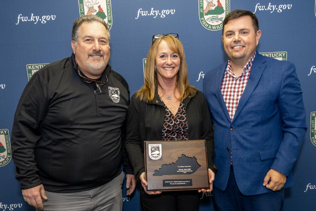 Pictured left to right Marketing Division Director Brian Blank, Brenda Ward-Hill, and Commissioner Rich Storm.