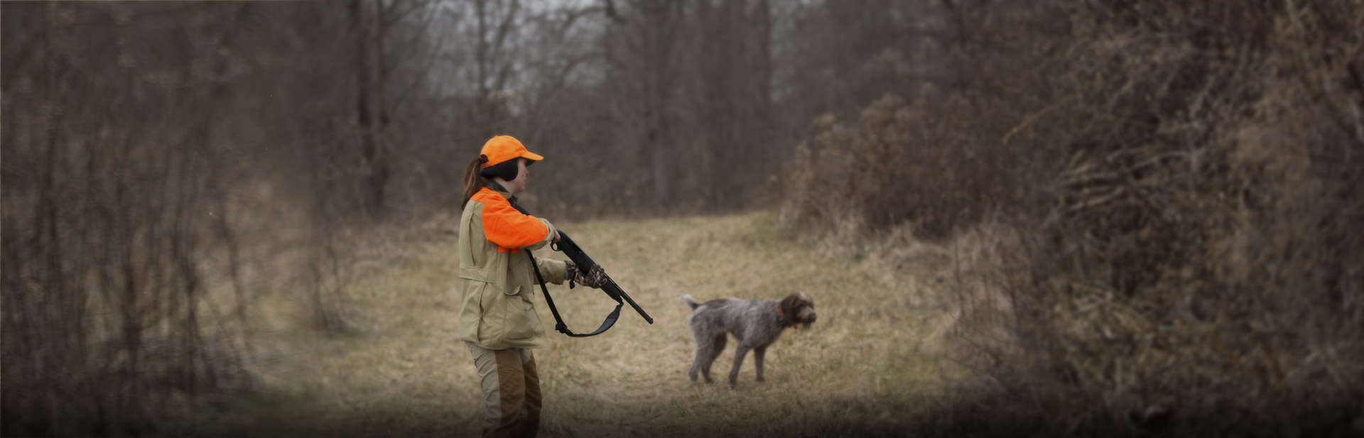 Hunter in a field hunting with a dog