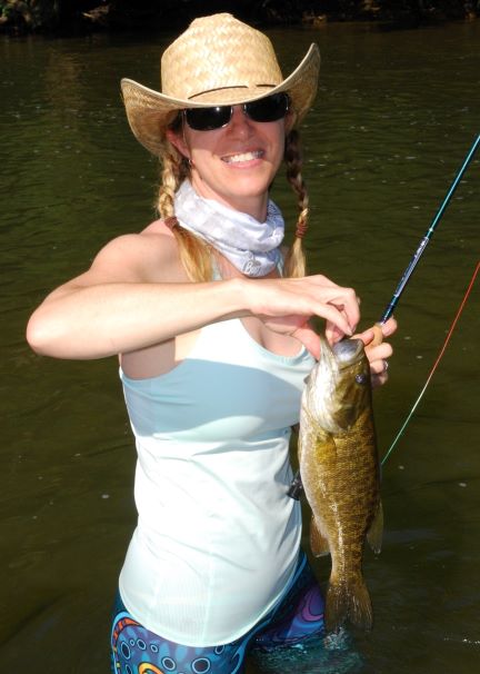 A woman is smiling for the camera while fishing